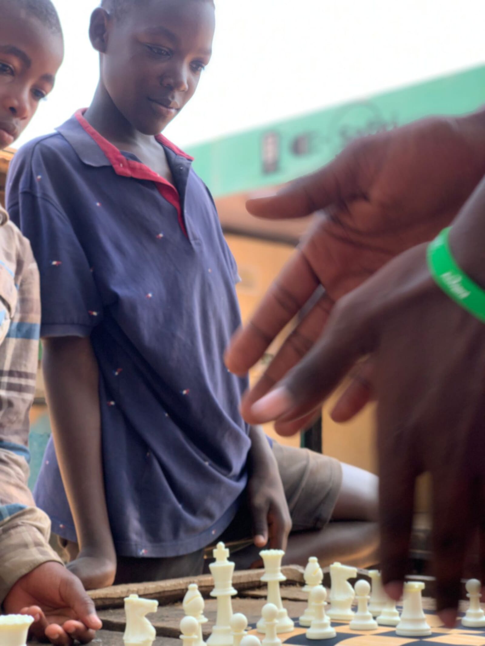 Children gathered around a chess game